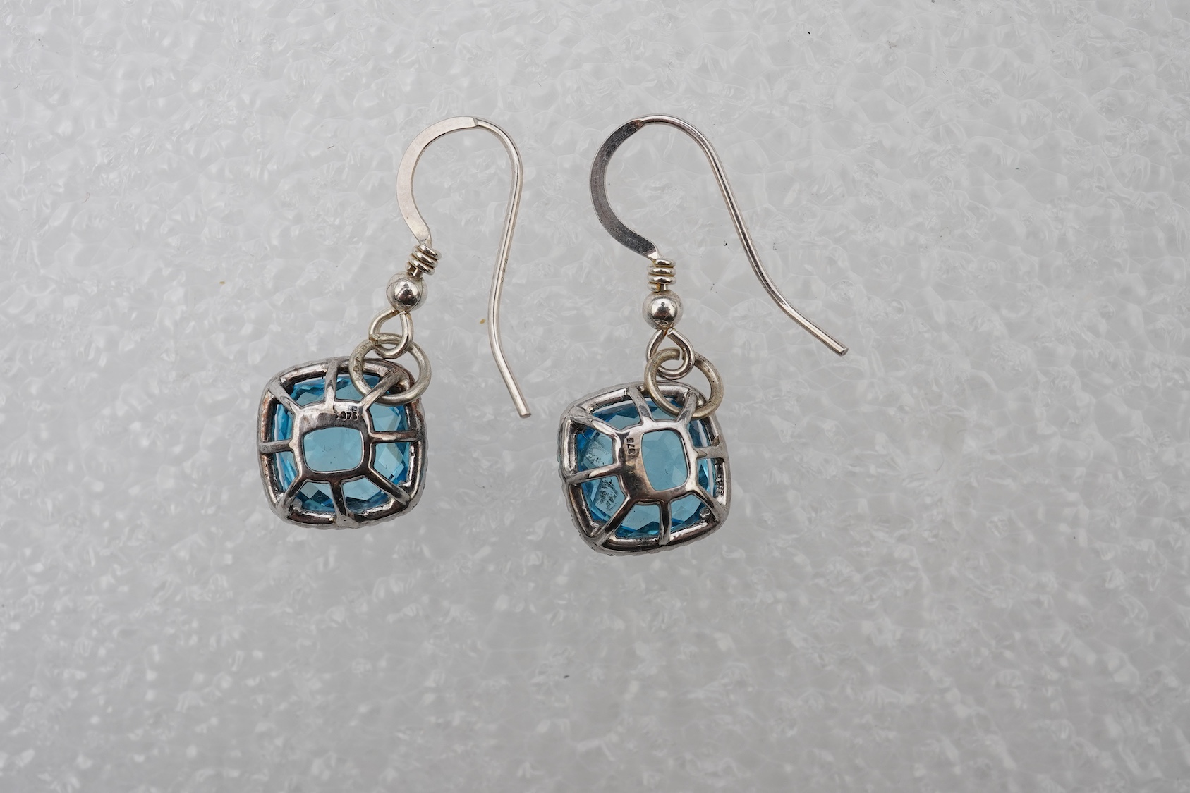 A pair of blue topaz and diamond pendant earrings